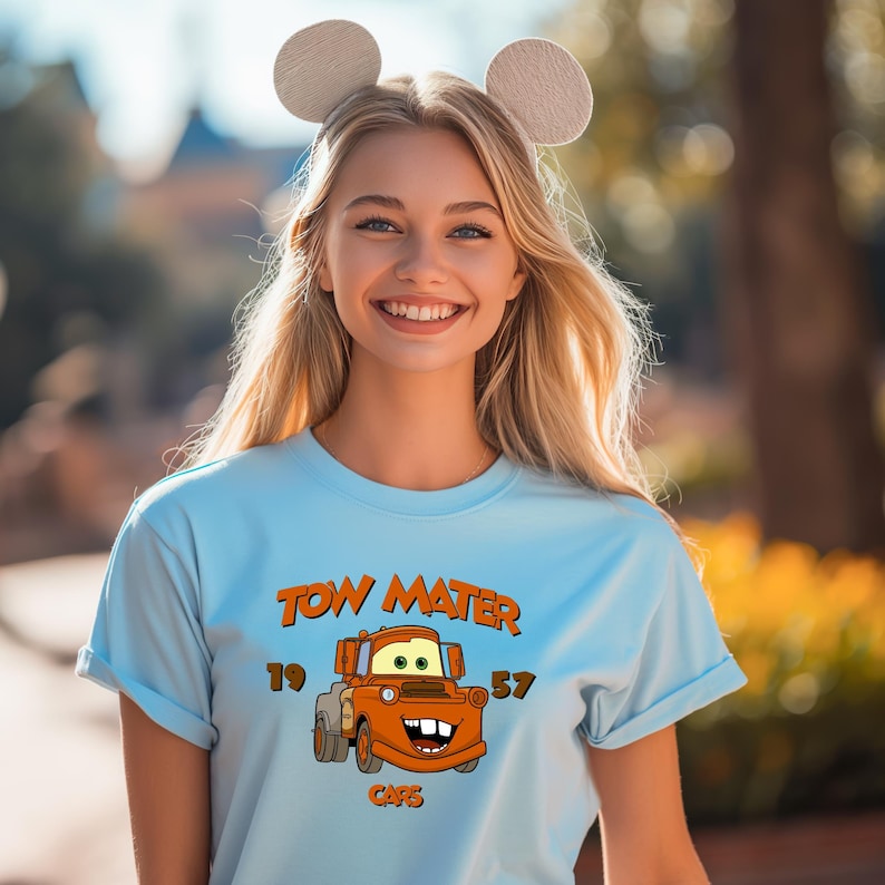 a woman wearing a blue shirt with mickey ears on her head