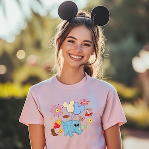 a woman wearing a pink shirt with mickey mouse ears on her head