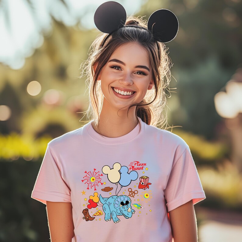 a woman wearing a pink shirt with mickey mouse ears on her head