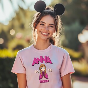 a girl wearing a pink shirt with a minnie mouse ears on her head