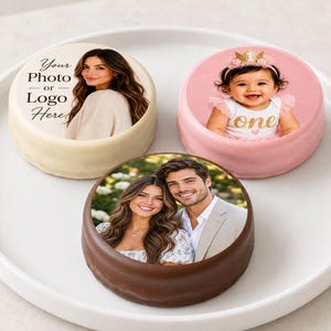 May include: Three round cookies with edible photo prints. One white cookie features a woman and the text Your Photo or Logo Here. One pink cookie shows a baby wearing a crown. One brown cookie displays a couple smiling together in an outdoor setting.