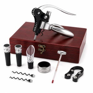 Puede incluir: Un juego de accesorios para vino que incluye un sacacorchos de palanca plateado y negro, dos tapones negros, un vertedor transparente, un anillo antigoteo plateado, un termómetro, un cortacápsulas y dos espirales de repuesto en una caja de madera.