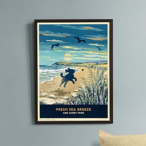 May include: A framed print depicting a beach scene with a dog playing fetch, and the text "FRESH SEA BREEZE AND SANDY PAWS." A light brown dog is lying down in front of the print. The print has a dark brown frame.