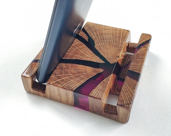 May include: A wooden phone stand with a pink and black resin inlay. The stand has a slot for holding a phone upright.