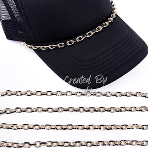 May include: A set of six gold and black chain trim for hats. The chains are approximately 18 inches long and have a classic curb link design. The chains are shown on a black mesh trucker hat.