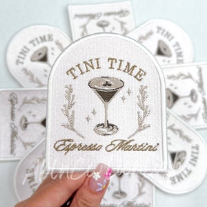 Puede incluir: Parche blanco bordado con una copa de martini y el texto "Tini Time Espresso Martini".