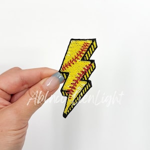 May include: Yellow and red lightning bolt shaped iron-on patch with a baseball stitch design.