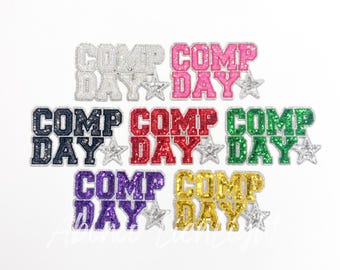 May include: Six iron-on patches with the text "Comp Day" in different colors, including silver, pink, red, green, purple, and gold. Each patch features a star design.