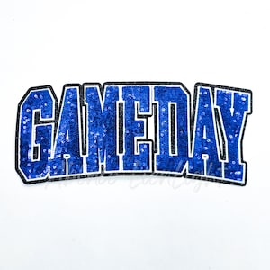 May include: A blue sequined "GAMEDAY" patch with a black border. The letters are bold and outlined in white, creating a striking contrast against the blue sequins. The patch is designed for apparel and accessories.