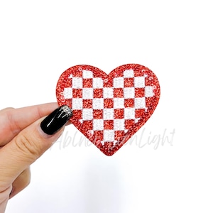 May include: Red and white checkered heart-shaped patch with a glittery finish.