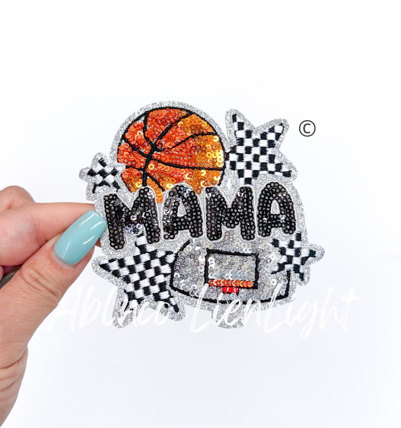 May include: A silver sequin iron-on patch with the word "MAMA" in black sequins, a basketball, a basketball hoop, and two black and white checkered stars.