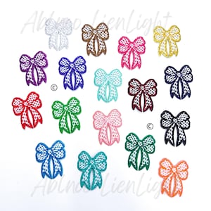 May include: Assortment of 18 embroidered iron-on patches in various colors, featuring a bow design with a polka dot pattern.