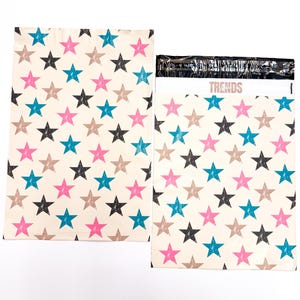 May include: Two white poly mailers with a star pattern in pink, blue, black, and brown. The mailer on the right has the word "TRENDS" printed on it.