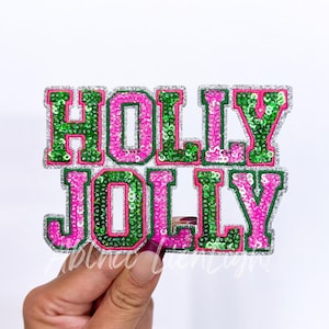 May include: A pink and green sequined iron-on patch with the words "HOLLY JOLLY" in a festive font.