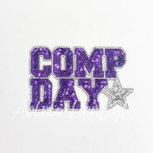 May include: Purple and silver sequined iron-on patch with the text "COMP DAY" and a silver star.