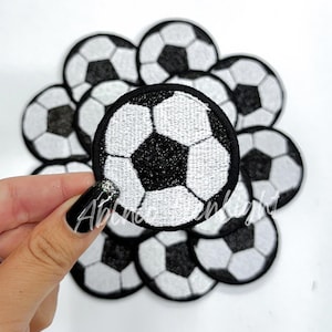 May include: A set of ten black and white embroidered iron-on patches featuring a soccer ball design.