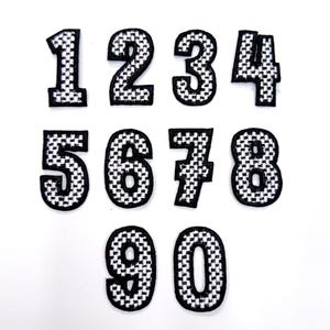 May include: Ten black and white checkered iron-on patches with the numbers 1 through 10.