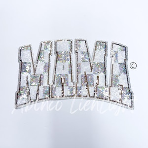 May include: A white and silver sequined iron-on patch that says "MAMA" in large, bold letters.