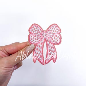 May include: Pink and white checkered bow with glitter, a cute embellishment for crafts and clothing.