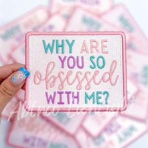 May include: Pink and white embroidered iron-on patch with the text "Why are you so obsessed with me?" in a playful font.