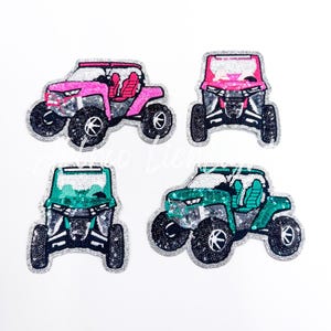 Pode incluir: Quatro patches de ve&iacute;culos off-road com lantejoulas em rosa e verde-azulado. Cada patch apresenta um design detalhado de um UTV lado a lado com pneus grandes e uma borda de glitter prateado. Os patches est&atilde;o em um fundo branco.