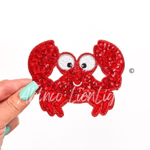 May include: Red sparkly crab applique with white eyes and a smiling mouth.