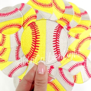 May include: A stack of yellow and white softball patches with red stitching. The patches are round and have a diameter of approximately 3 inches.