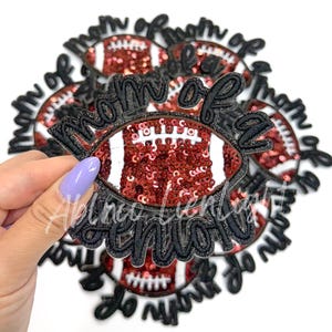 May include: Multiple black and red iron-on patches with the text "Mom of a  " and a red and white football design.