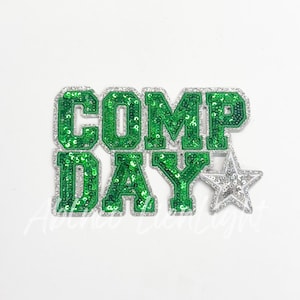 May include: Green and silver sequined iron-on patch with the text "COMP DAY" and a silver star.