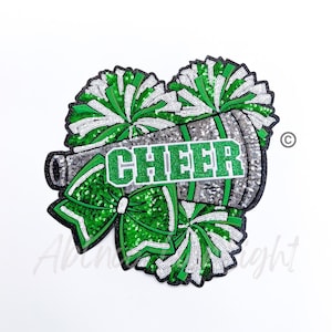 May include: Green and silver sequin cheerleading patch with a megaphone, pom-poms, and a bow. The word "CHEER" is written on the megaphone.