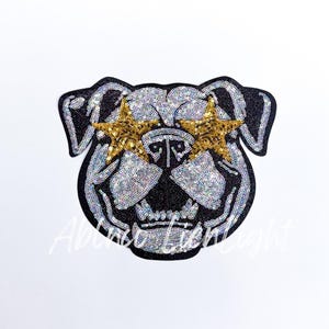 May include: A black and white sequined bulldog patch with gold star-shaped sequins over the eyes.