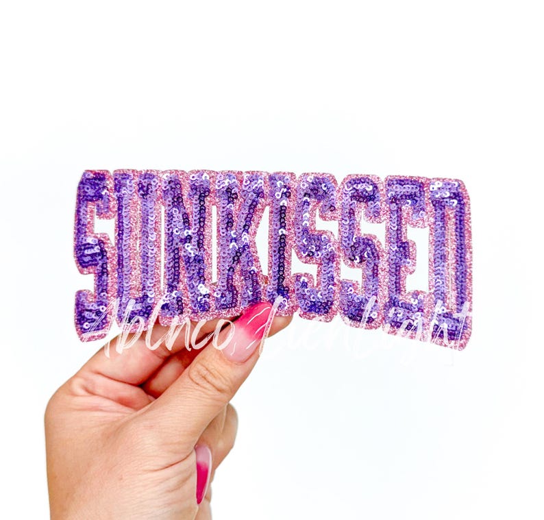 May include: Purple and pink sequined iron-on patch that says "Sunkissed".