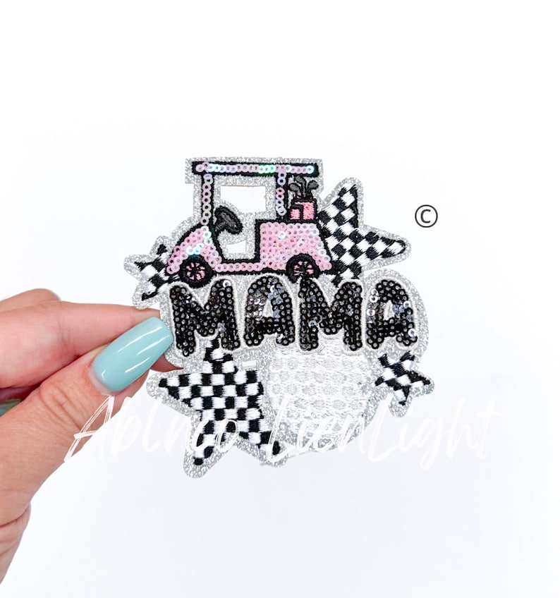 K&ouml;nnte beinhalten: Ein glitzernder rosa Golfwagen mit Golfschl&auml;gern im Kofferraum, umgeben von schwarz-wei&szlig;en karierten Sternen und dem Wort "MAMA" in schwarzen Pailletten.