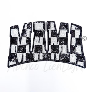 May include: Black and white checkered fabric patch with the word "MAMA" in large, bold letters. The patch is made of sequins and has a shiny finish.