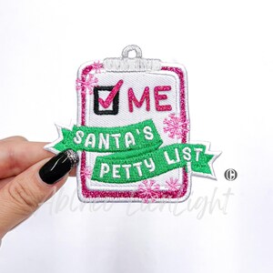 May include: A white, pink, and green embroidered patch with a checklist and the text "ME" checked off. A green banner below reads "SANTA'S PETTY LIST".