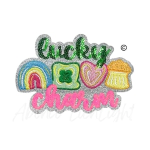May include: A glittery patch with the words "lucky charm" in green and pink. The design includes a rainbow, a four-leaf clover, a heart, and a small cake. The patch is outlined in silver glitter.