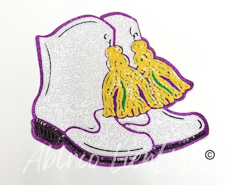 May include: A white sequined boot with purple trim and two yellow and green sequined tassels.