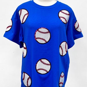 May include: A royal blue t-shirt with sequined baseballs in white and red.