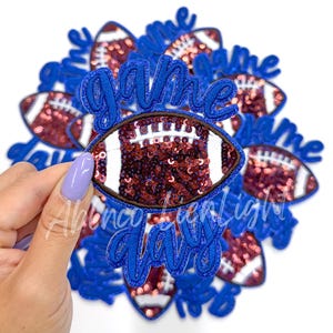 May include: A set of 10 iron-on patches featuring a football design with sequins and the words "game day" in blue.