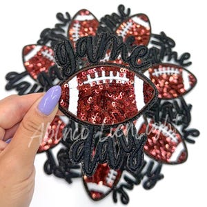 May include: A set of 10 iron-on patches featuring a football design with red sequins and the text "game day".