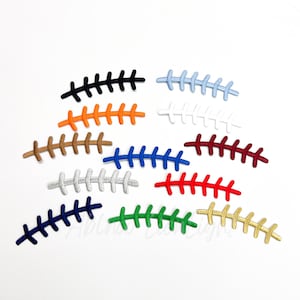 May include: A collection of colorful shoelace replacements in various shades, including black, orange, brown, blue, silver, red, navy, green, and gold. Each replacement is designed to mimic the look of a football's stitching, offering a unique style.
