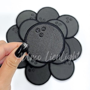 May include: A set of ten black felt iron-on patches featuring a bowling ball design. Each patch is approximately 2 inches in diameter.