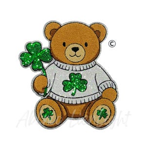 May include: A brown teddy bear wearing a white sweater with a green shamrock design. The bear holds a large green shamrock and has shamrocks on its paws. The image has a sparkly, glittery appearance.