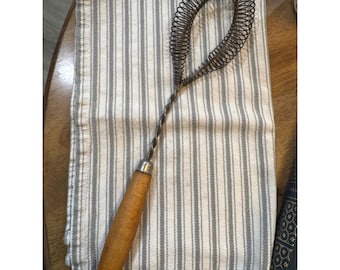 Batidor de alambre en espiral vintage con mango de madera rústica y resorte en espiral. Herramienta de cocina rústica.