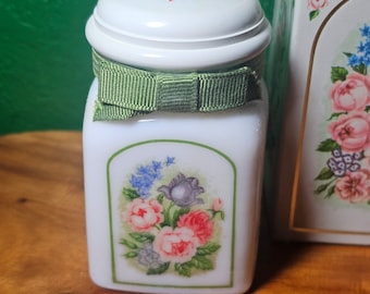 Puede incluir: Tarro de cerámica blanco con una cinta verde y un diseño floral. El tarro tiene una tapa blanca con un diseño floral.
