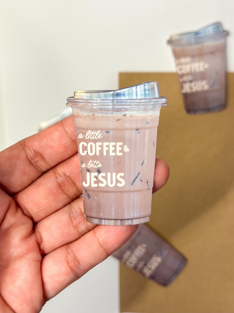 May include: A sticker of a brown iced coffee cup with the text "a little coffee & a lotta jesus" printed on it.
