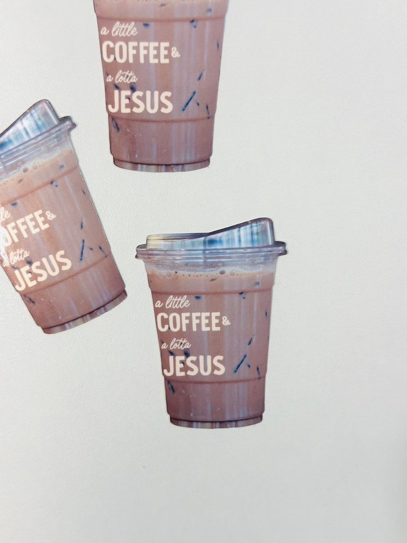 May include: Three iced coffee cups against a white background. The cups have clear plastic lids and are filled with a brown liquid. The text on the cups reads "a little COFFEE & a lotta JESUS".