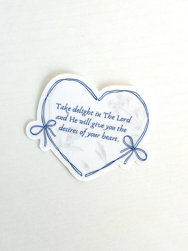 May include: A heart-shaped sticker with a blue outline and a floral design. The sticker features the text "Take delight in The Lord and He will give you the desires of your heart."