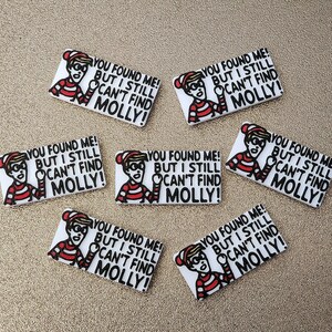 May include: Set of 7 white rectangular stickers with a cartoon character wearing a red and white striped shirt and a red hat. The character is pointing to the right and the text on the sticker reads "You found me! But I still can't find Molly!"