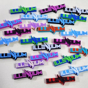 May include: A collection of colorful plastic keychains with the word "ILLENIUM" printed on them. The keychains are in various colors, including blue, green, pink, red, and white.